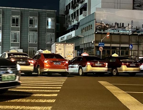 △四五辆出租车亮着“空车”灯，横在秣陵路路口的人行横道上。